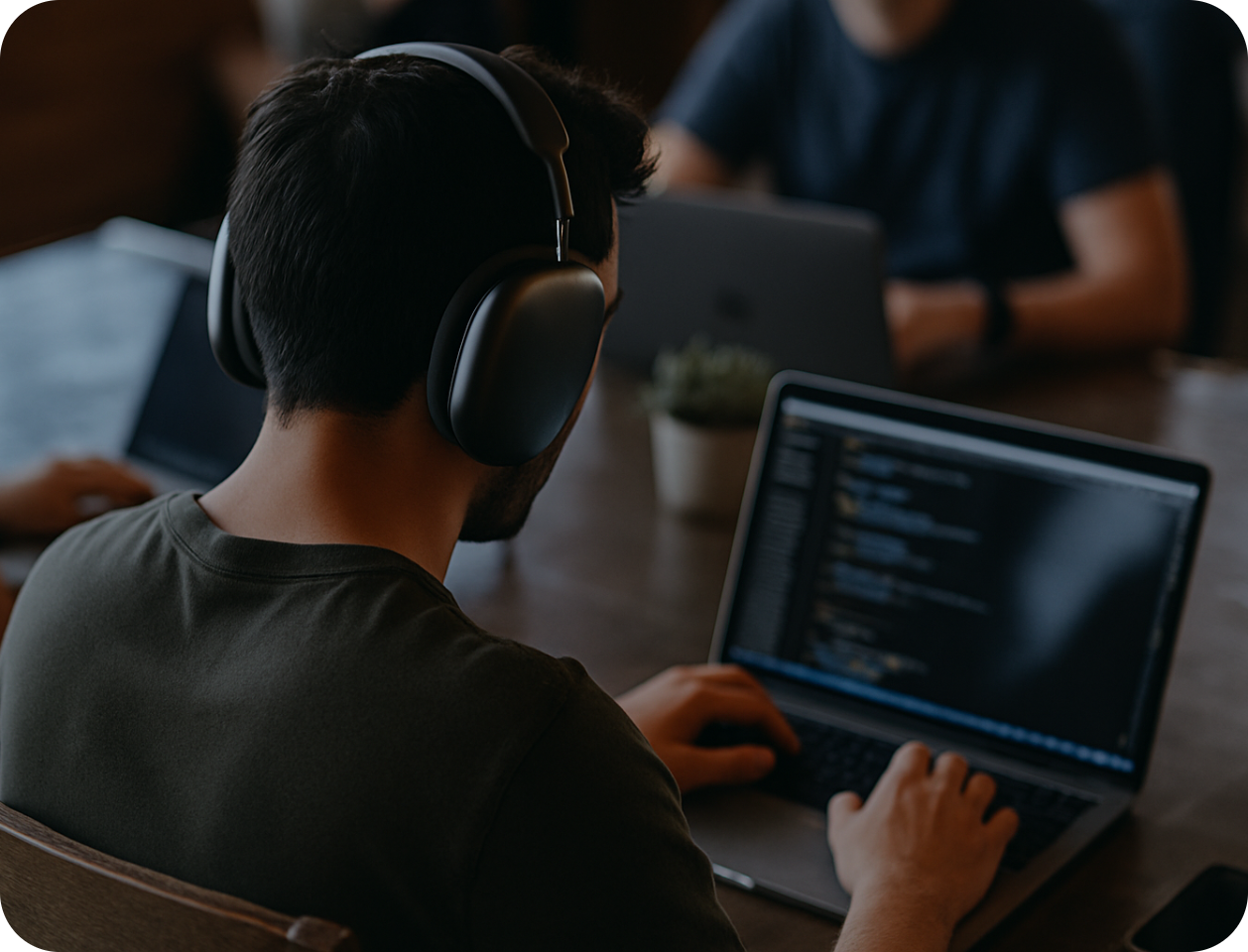 a man wearing headphones is typing on a laptop